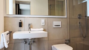 Ein modernes Badezimmer mit Waschbecken, Toilette und Dusche.