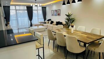 Un comedor moderno con una mesa y sillas de madera, un sofá y una planta en maceta.