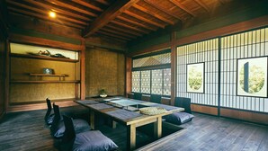 Una habitación tradicional japonesa con suelo de tatami, una mesa de madera baja y puertas correderas shoji.