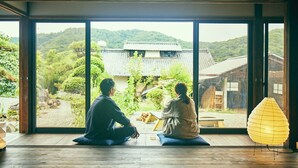 Una habitación con amplios ventanales que ofrecen vistas a edificios tradicionales y zonas verdes.