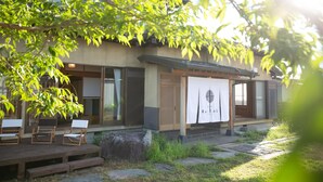 Ein traditionelles japanisches Gebäude mit Holzterrasse, Außenbereich und einem Banner mit Text.