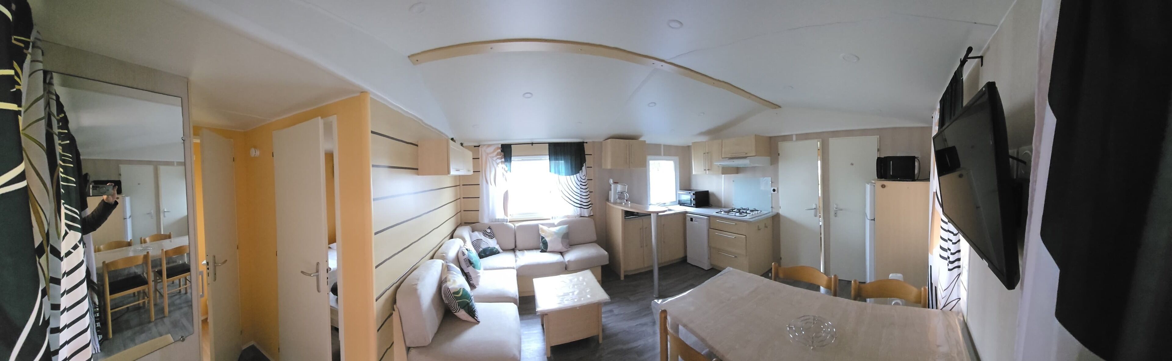 A compact living space with a kitchenette, a dining area, and a sofa.