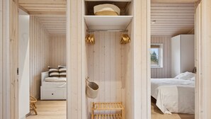 Ein Schlafzimmer mit Bett, Nachttisch, hängender Ampel und Kleiderschrank.