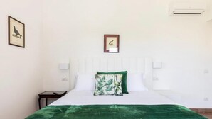 A neatly arranged bedroom with a bed, a nightstand, and two wall-mounted lamps. - Clivia- 03 bedroom villa with private terrace (Massa Lubrense)