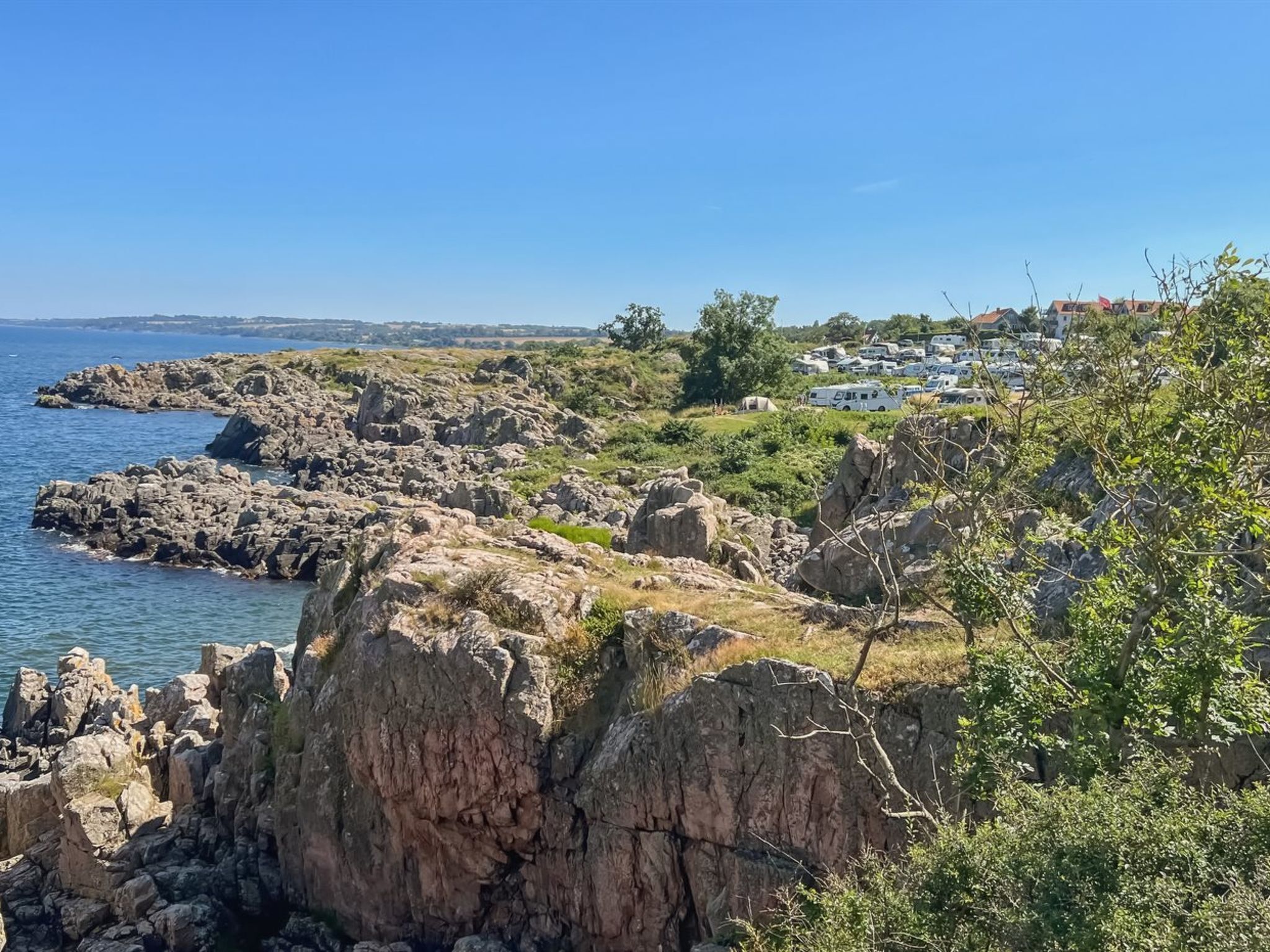 Eine Küstenlandschaft mit felsigem Gelände und freiem Blick auf das Meer.