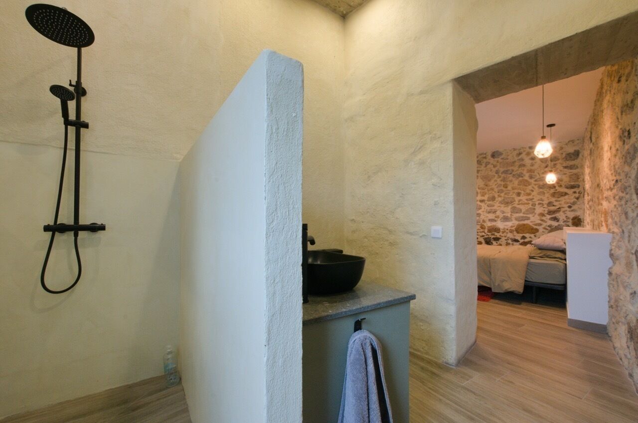 Une salle de bain avec une douche, un lavabo et un porte-serviettes.