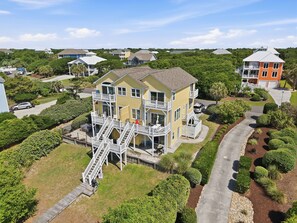 A multi-story residential building with a prominent staircase, a balcony, and a driveway. - Beach Allure West | Pet-Friendly Oceanfront Duplex (Emerald Isle)