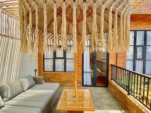 A cozy interior with a sofa, a wooden table, and a macramé hanging decoration. - Baliris Home Boutique (Legian)