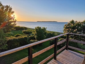 A wooden deck with a view of the sea and distant land. - Spacious waterfront family holiday (Føllenslev)