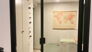 Ein Schlafzimmer mit einem Bett, einer Karte an der Wand und einem Kleiderschrank mit runden Griffen.