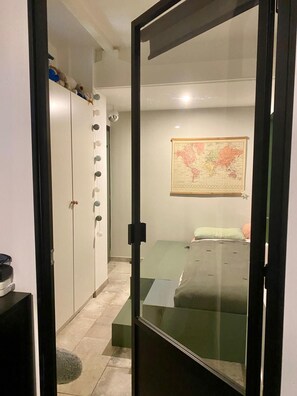 A bedroom with a bed, a map on the wall, and a wardrobe with circular handles. - La Maison des 9 Ecluses - Swimming pool & cathedral view (Béziers)