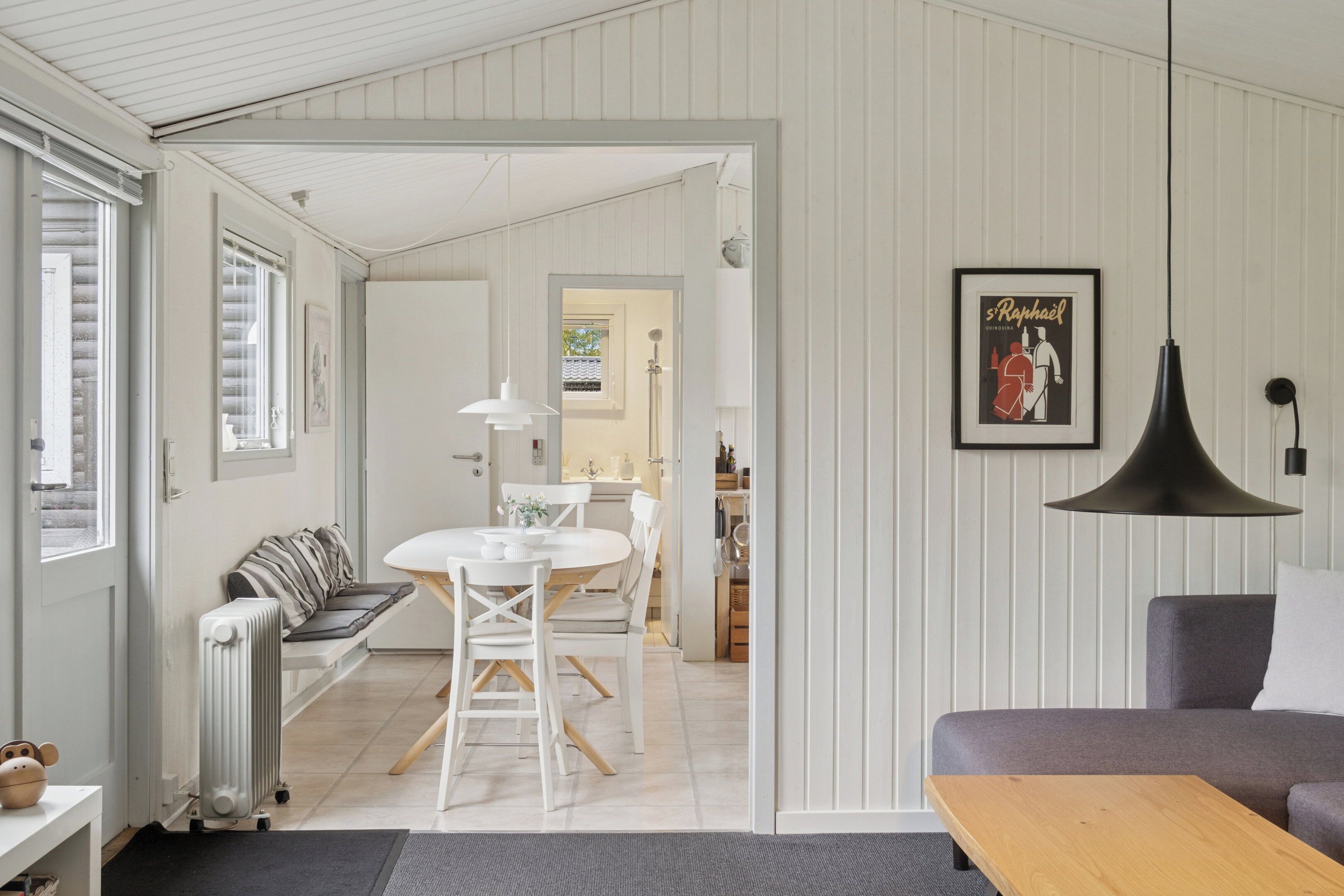 Un salon moderne avec un canapé, une table à manger et une cuisine en arrière-plan.