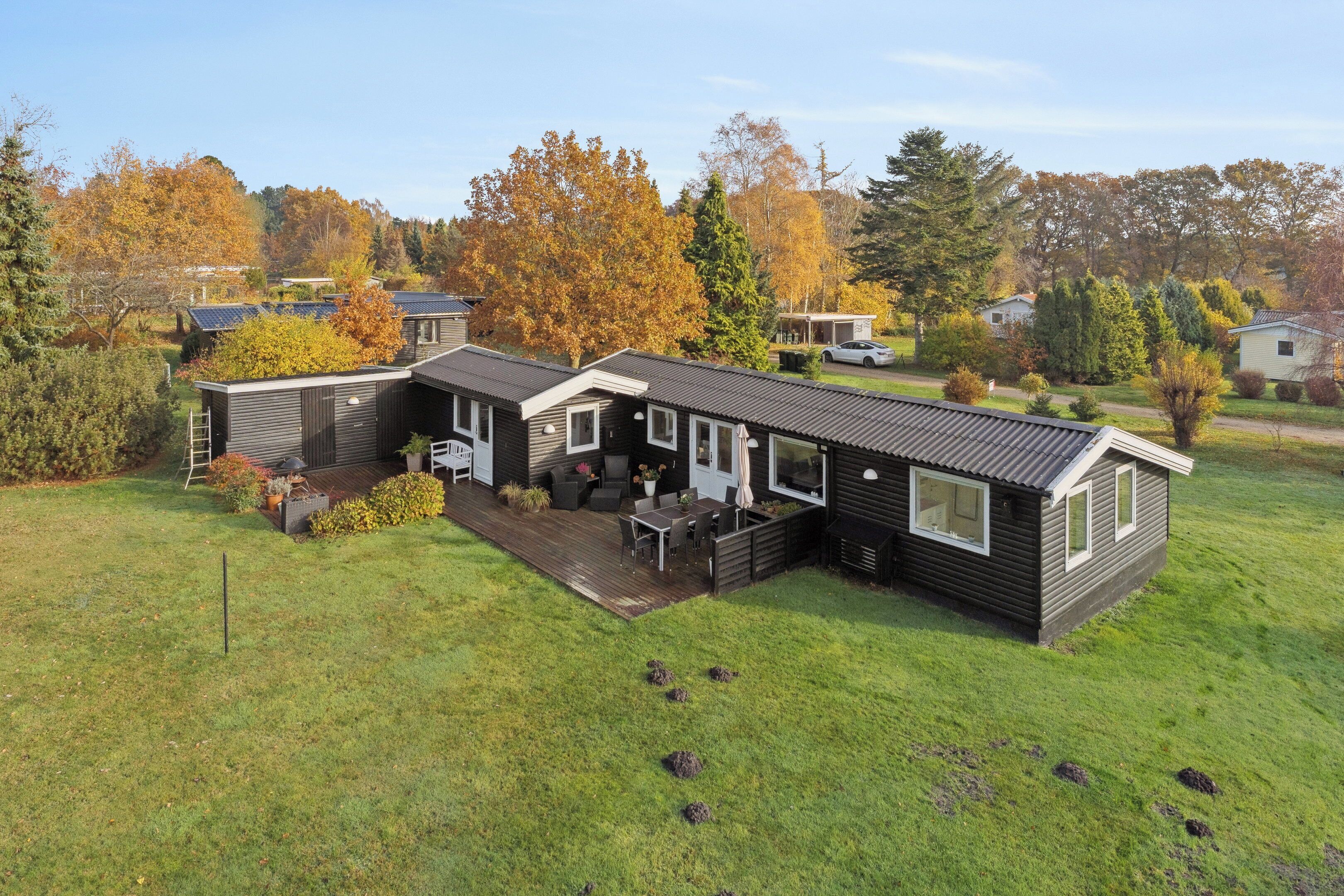 Et moderne hus med to etager, en terrasse, en træterrasse og en garage.