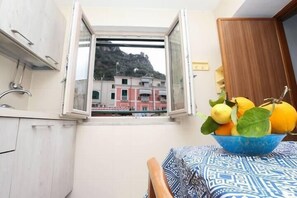 A small balcony with a view of buildings and a bowl of fruit on a table. - La dimora del Marinaio   Amalfi (AMALFI)