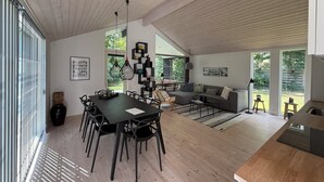Amplia sala de estar con una mesa de comedor, sofás y zona de cocina.