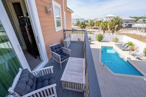 A deck with outdoor seating and a pool. - August 2026 Big Savings!!! Large home with private pool, hot tub (Eastpoint)