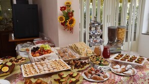 A buffet table with various food items, including pastries, fruits, and desserts. - Hotel Mimosa (Riccione)