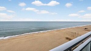 A beach view from a balcony with a clear sky and calm sea. - Beachfront Condo/ Pool/ Surfing/ Fishing / EW 1101 (Virginia Beach)