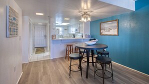 A modern kitchen with a central island, bar stools, and a dining table. - King`s Getaway Oceanview Pool (Daytona Beach Shores)