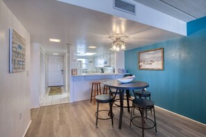 A modern kitchen with a central island, bar stools, and a dining table. - King`s Getaway Oceanview Pool (Daytona Beach Shores)