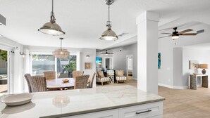 A spacious kitchen with a marble countertop, white cabinetry, and pendant lighting. - C-View Florida: Canal Front Home w/ Dock! (Anna Maria)