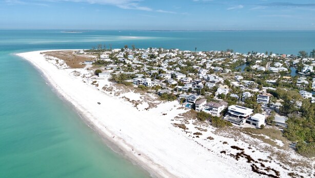 An aerial view of a coastal residential area with houses along the beach and a marina. - C-View Florida: Canal Front Home w/ Dock! (Anna Maria)