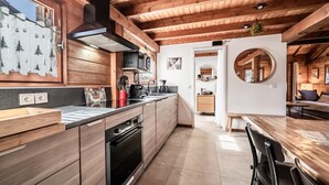 A modern kitchen with wooden cabinets, a built-in oven, and a large island with a sink. - Chalet “6p Premium - Zibeline” with Mountain View, Private Terrace, and Wi-Fi (Verchaix)