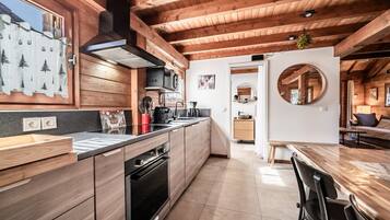 Eine moderne Küche mit Holzausstattung, einem eingebauten Ofen und einer großen Kochinsel mit Spüle.