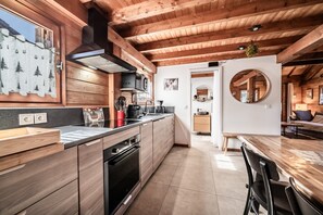 A modern kitchen with wooden cabinets, a built-in oven, and a large island with a sink. - Chalet “6p Premium - Zibeline” with Mountain View, Private Terrace, and Wi-Fi (Verchaix)
