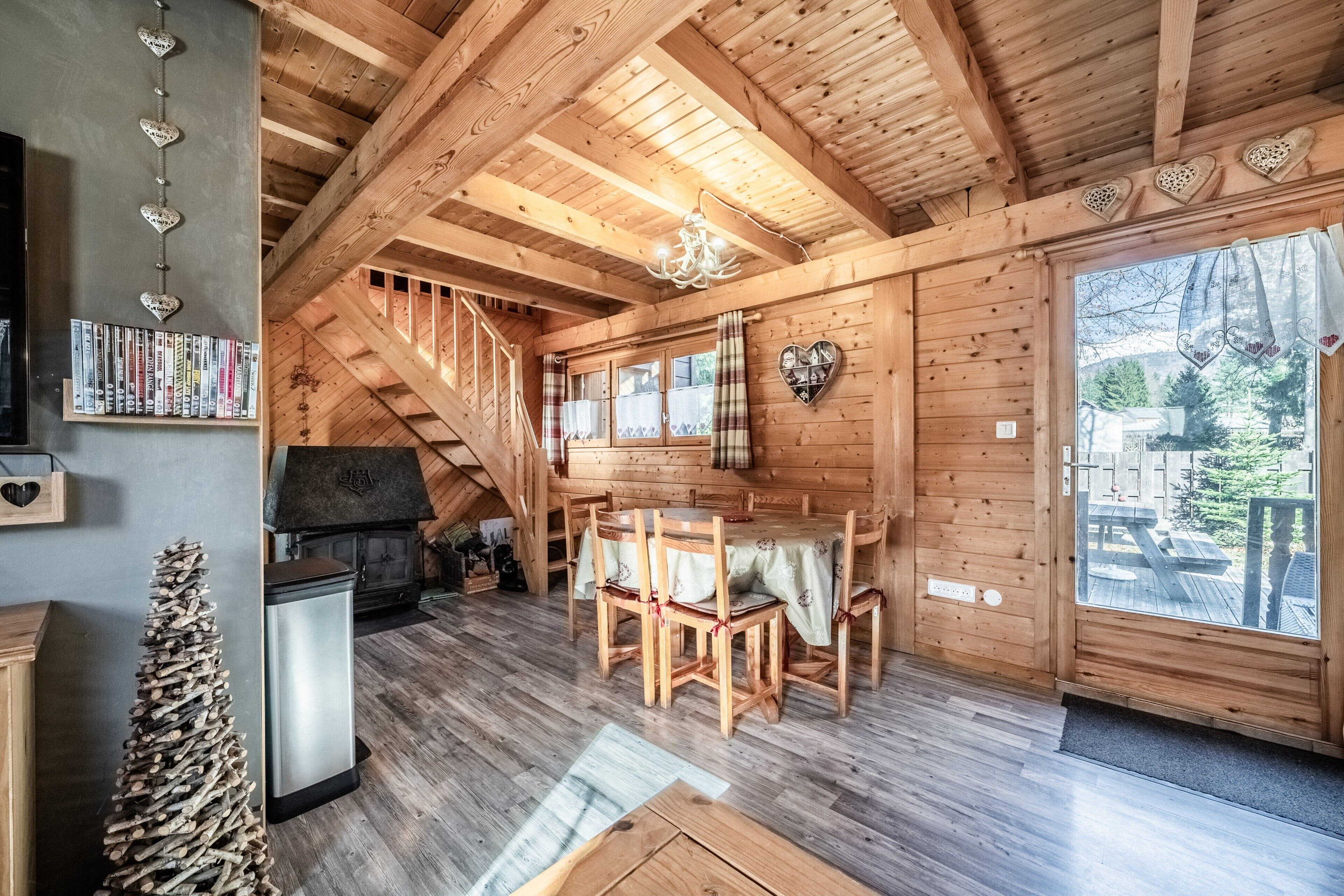 Un intérieur en bois comprenant un coin repas, des étagères et une cheminée.