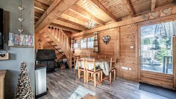 Un interior de madera con comedor, estanterías y chimenea.
