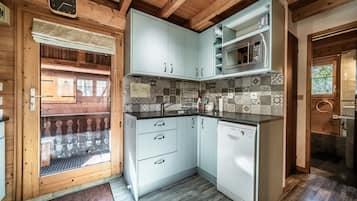 Una cocina con armarios azul claro, un microondas de acero inoxidable y un lavavajillas Bosch.