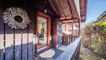 Een houten gebouw met een balkon, een houten krans en een heldere lucht.