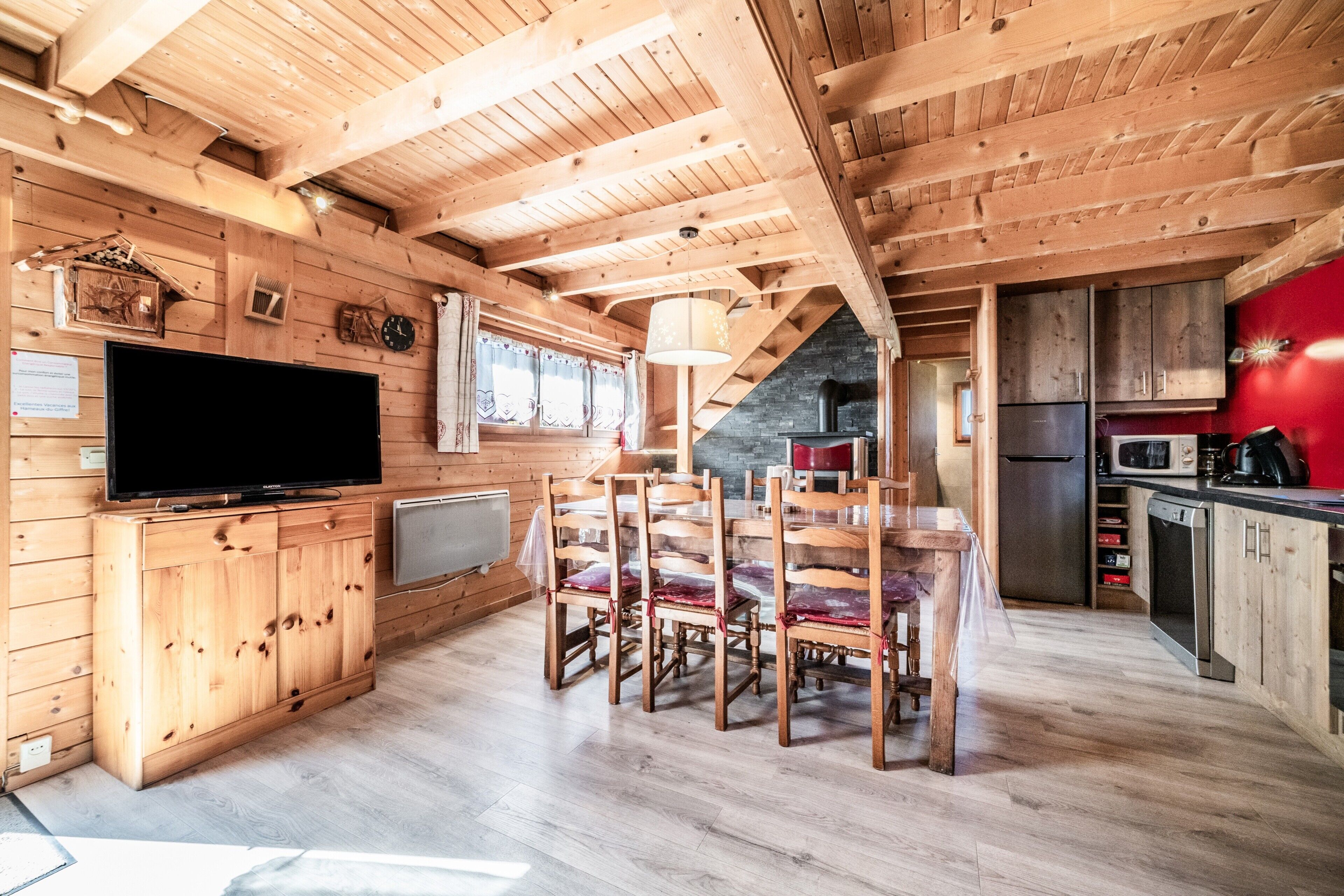Un interior de madera con comedor, cocina y televisor.