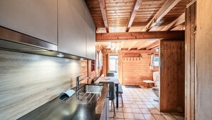 A modern kitchen with a stainless steel sink, wooden cabinets, and a wooden ceiling. - Chalet "6p Comfort - The Royal Eagle" with Mountain View, Shared Terrace and Wi-Fi (Verchaix)
