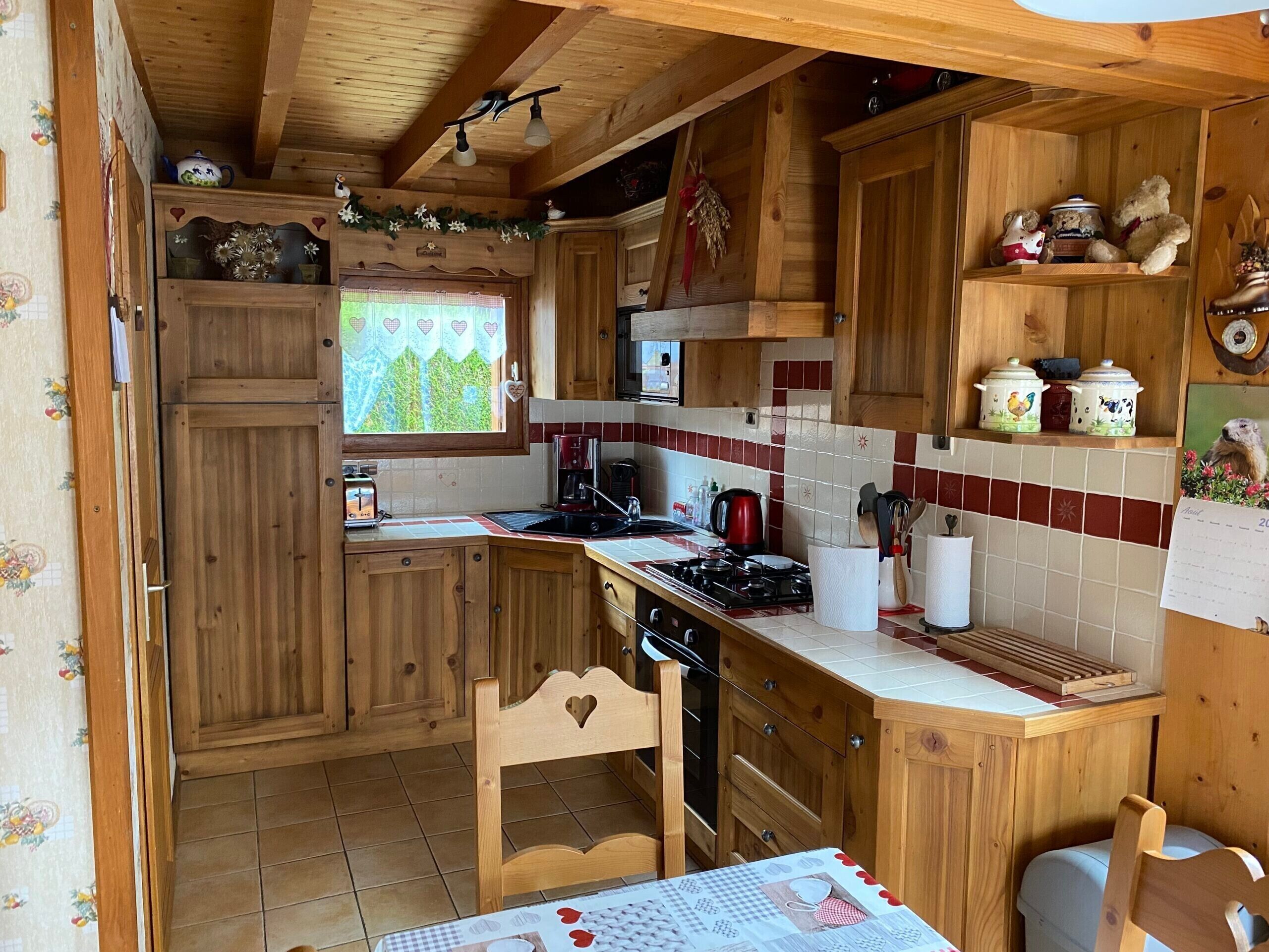 Una cucina in legno con un fornello, un lavello e mobili impiallacciati.