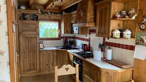 Una cucina in legno con un fornello, un lavello e mobili impiallacciati.