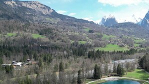 Un paysage montagneux avec un village, une rivière et un lac.