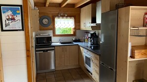 Une cuisine avec des meubles en bois, un réfrigérateur en acier inoxydable, un four à micro-ondes et un évier.