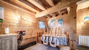 Et interiør i en træhytte med et træskab, en rensdyrpynt og et bord med dug.