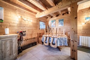 A wooden cabin interior with a wooden cabinet, a reindeer decoration, and a table with a tablecloth. - Chalet “6p Comfort – Le Bouvreuil” with Mountain View, Private Terrace & Wi-Fi (Verchaix)