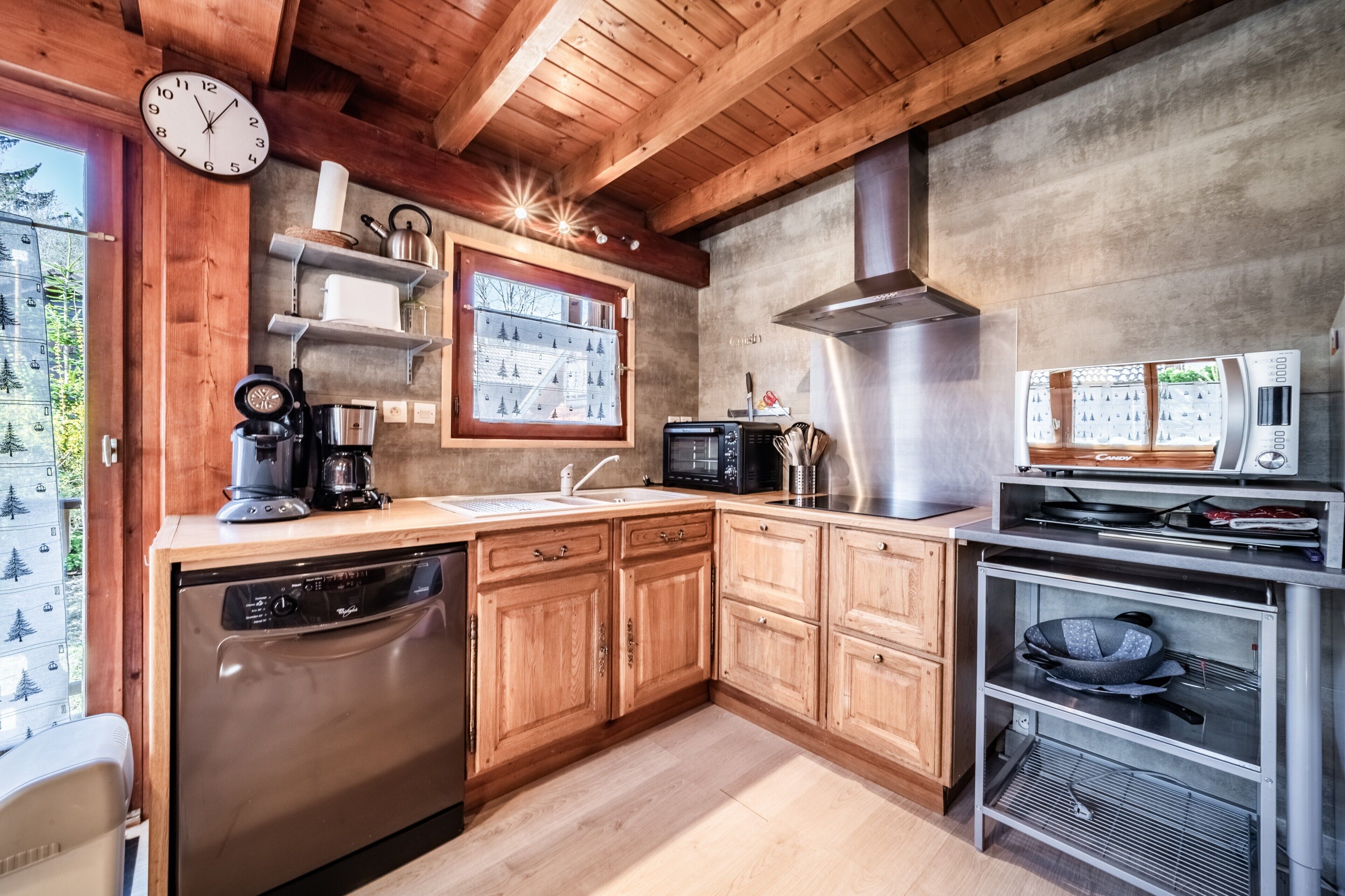 Une cuisine avec des meubles de rangement en bois, un lave-vaisselle, un four à micro-ondes et une cuisinière.