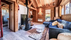 Un intérieur en bois avec un canapé, une table blanche et une cheminée.