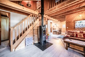 A wooden interior with a staircase, a fireplace, a sofa, and a dining area. - Chalet “6p Comfort – Le Grand Tétras”: Mountain View, Private Terrace & Wi-Fi (Verchaix)