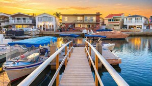 A marina with docked boats, a wooden pier, and waterfront houses.