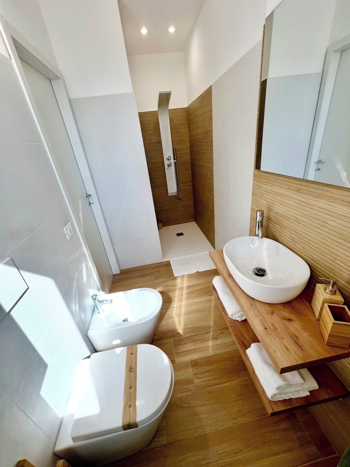 A modern bathroom with a double sink, a bathtub, and a shower.