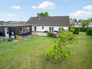 A residential building with a sloped roof, a fenced yard, and a small tree. - "Elene" -  from the sea by Interhome (Hadsund)