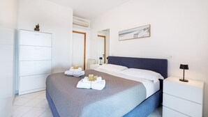 Une chambre d’hôtel avec un lit, une table de chevet, une armoire et un tableau au mur.