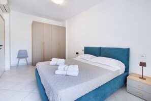 Ein Schlafzimmer mit Bett, Stuhl, Kleiderschrank und Nachttisch.