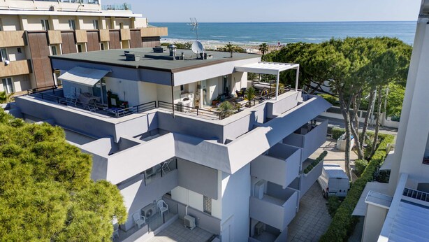 A modern multi-story building with a rooftop terrace, a pool, and a view of the sea. - Carinzia Comfort Plus 8 - Riviera Collection (RICCIONE)